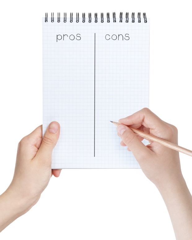 female teen girls holding notepad with pros cons